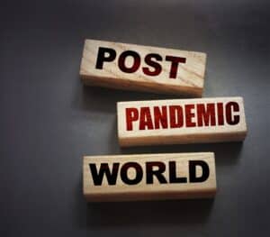 Three wooden blocks with words "mail," "pandemic," And "world" Written on it in alternating black and red