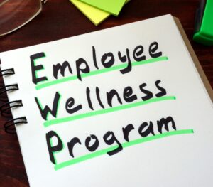 a notebook with the words "employee wellness program" written in black and underlined in neon green