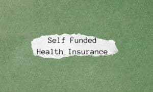 a green piece of paper with a ripped piece of white piece of paper on it that says "self funded health insurance"