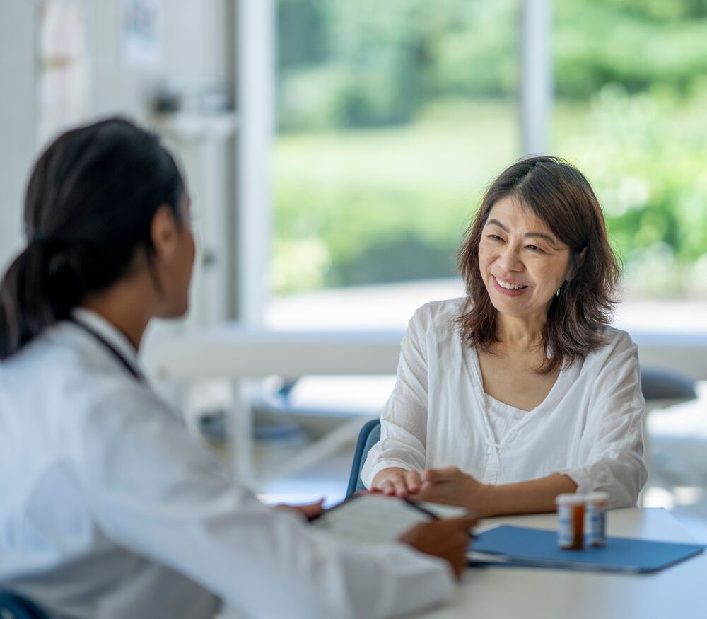 Promoting Wellness Employee Health Insurance Benefits a woman talking to a doctor