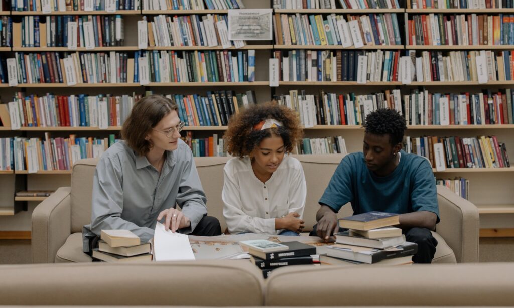 three students studying in a library