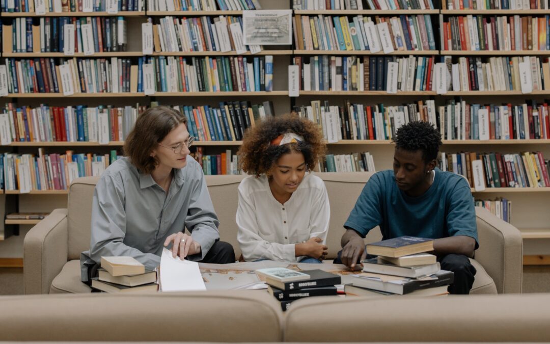three students studying in a library
